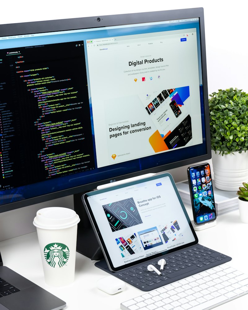 Monitor com código de um lado e a página de um site do outro